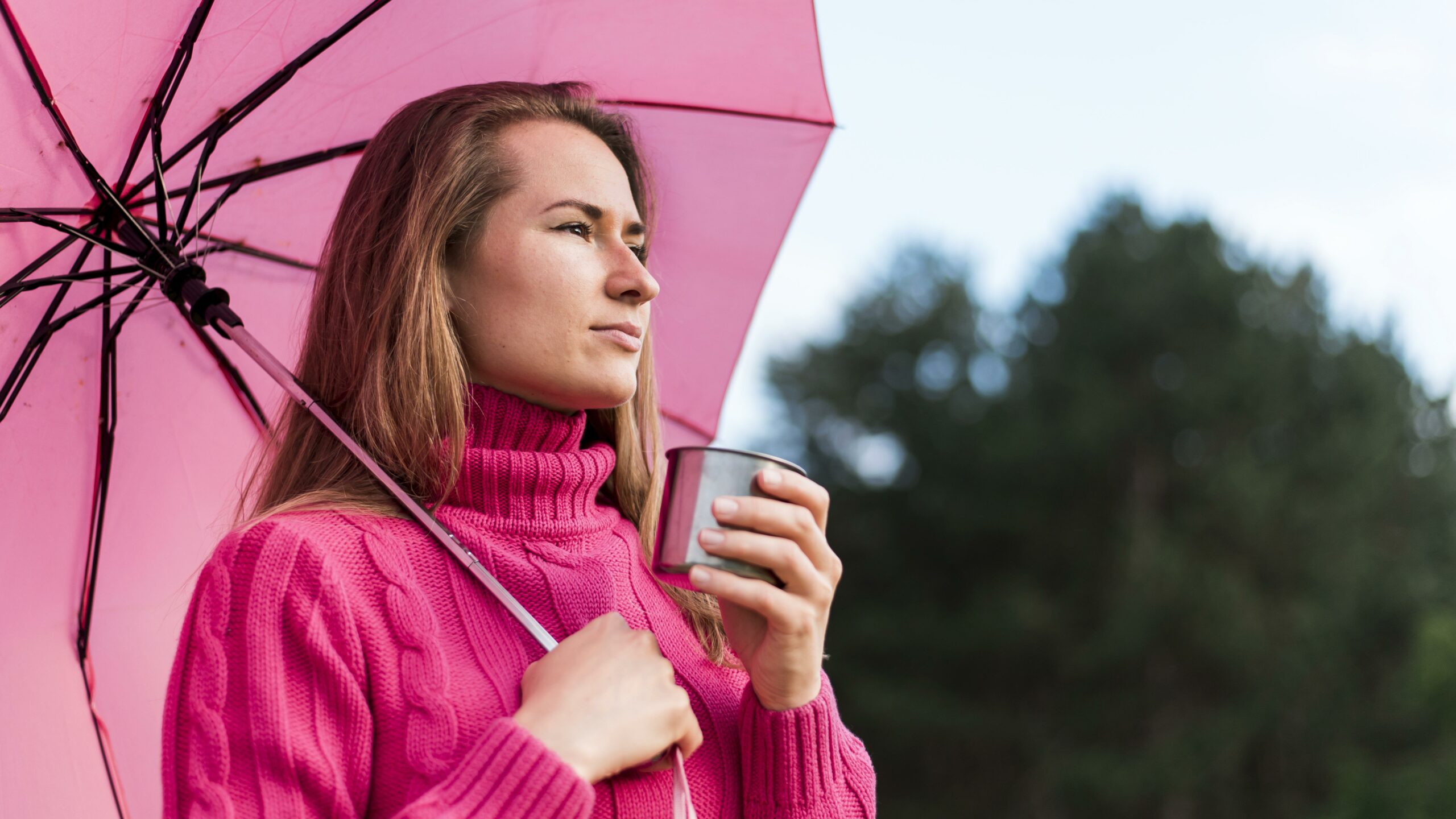 vue-laterale-femme-tenant-un-parapluie-rose